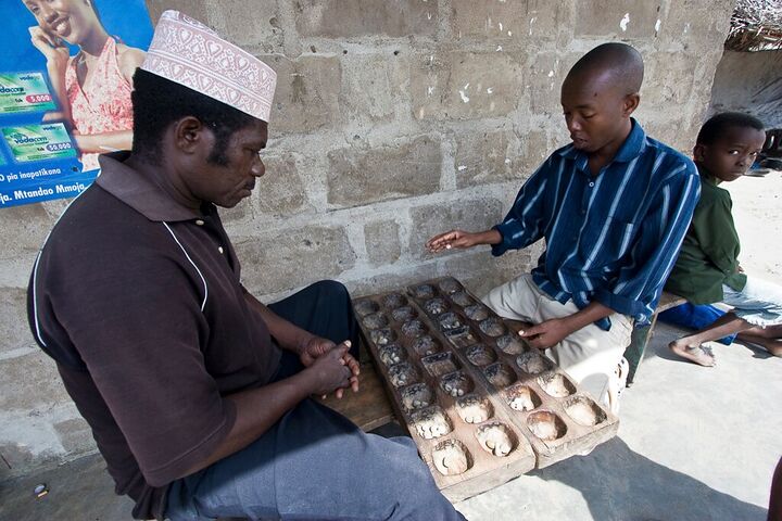 Men playing bao on a street bench