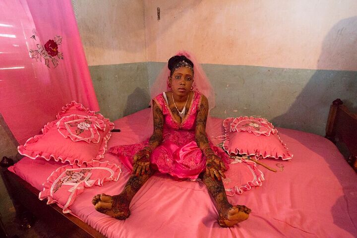 Bride with hennaed arms in a pink bridal room
