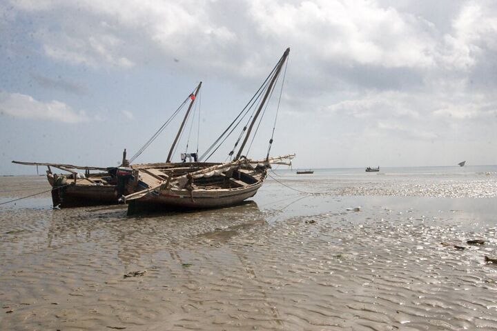 Two dhows resting on the sand at low tide