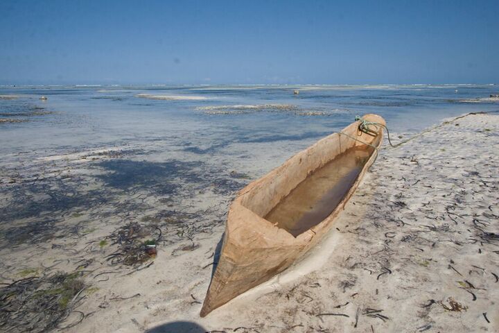 Dugout canoe on white sand at low tide