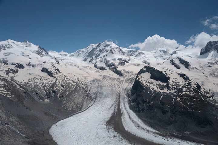 Glacier winding between snowy peaks