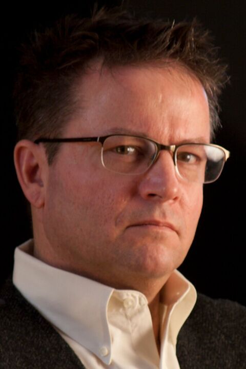 Man in glasses against a dark background
