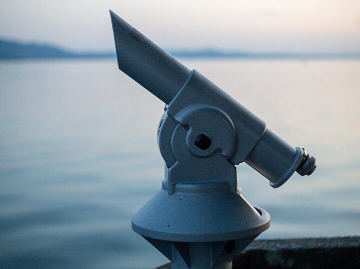 Coin-operated telescope overlooking the lake at dusk