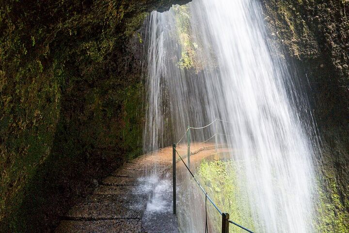 Waterfall pouring over a levada path