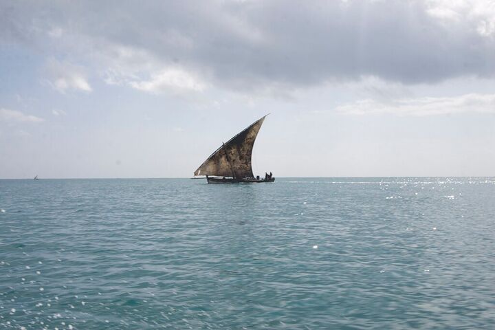 A lone dhow under sail on a grey sea