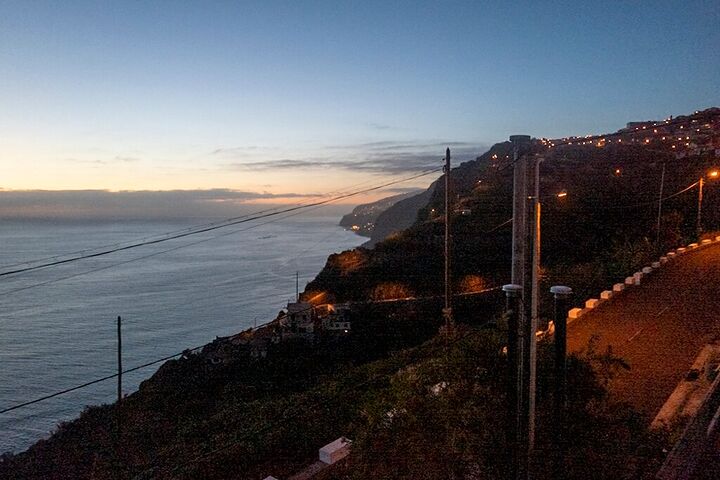 Coastal village lights at dusk above the sea