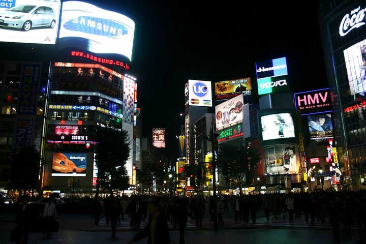 Shibuya crossing glowing with neon at night