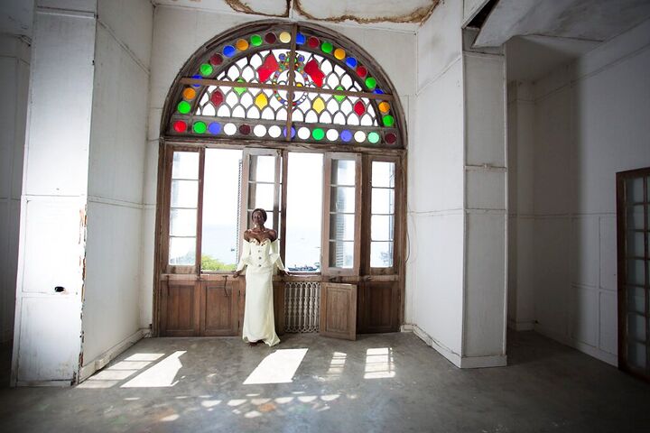 Bride standing in a doorway beneath a stained-glass window