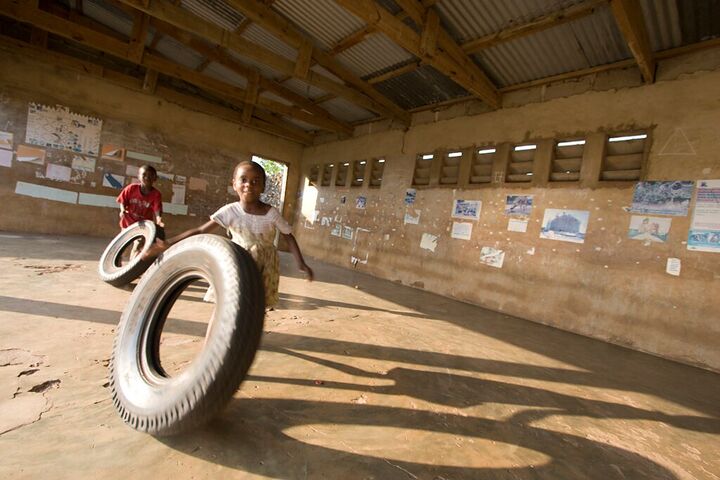 Children playing with a tyre in a schoolhouse