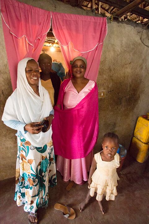 Family standing in front of a pink curtain