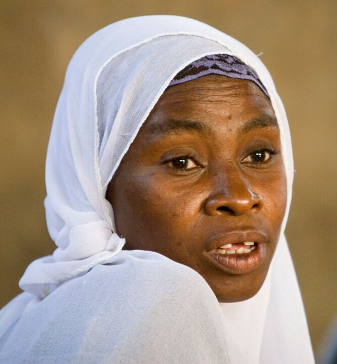 Woman in a white headscarf speaking at a meeting